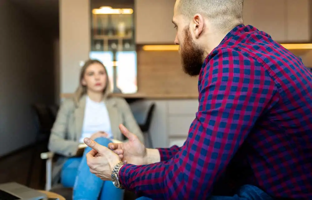 woman sits on couch attempting to cope with racing thoughts