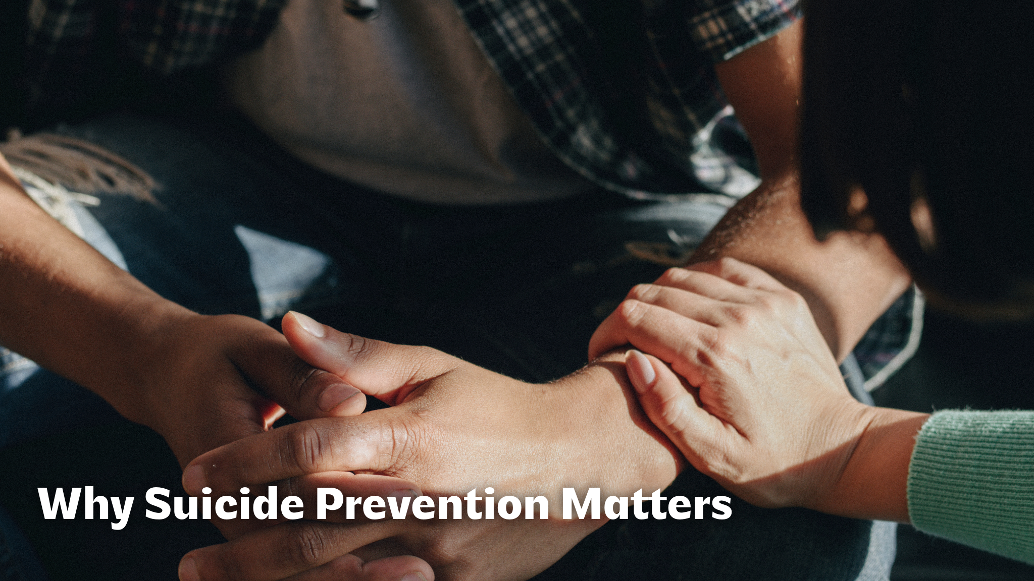 why-suicide-prevention-matters Close-up of one person gently holding the hands and forearms of another person, showing comfort and support. The text overlay on the image reads, "Why Suicide Prevention Matters."